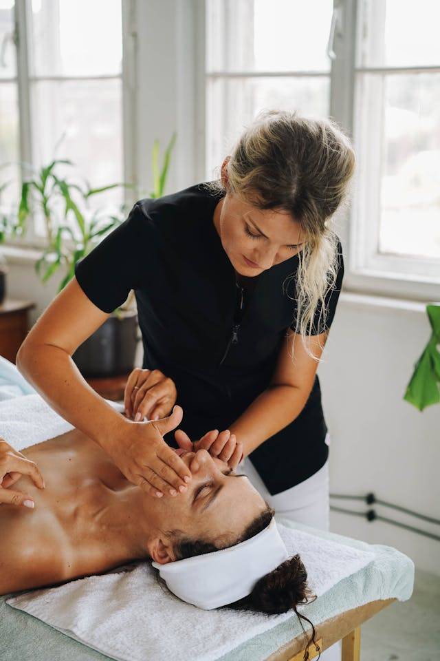 Skincare therapist performing facial treatment on client in serene wellness environment at Arlington Physical Therapy clinic.